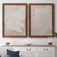 Set of two maple barnwood framed canvas prints depicting a coordinated art pair of soft blush and white painterly fields rendered as minimalist color-field abstracts above a dining room sideboard.