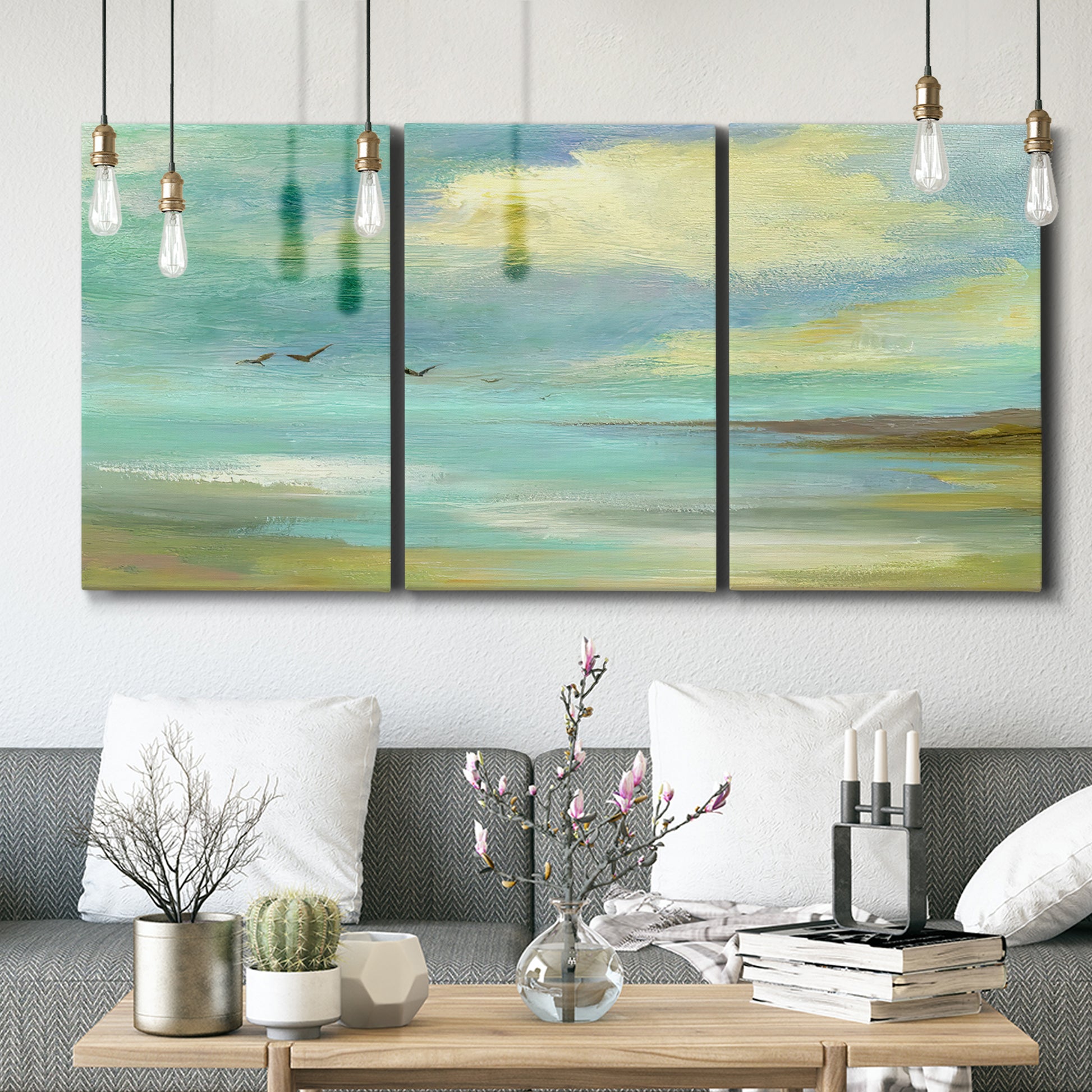 Three-panel canvas wall art featuring calm coastal drift patterns, displayed in a modern living room above seating.