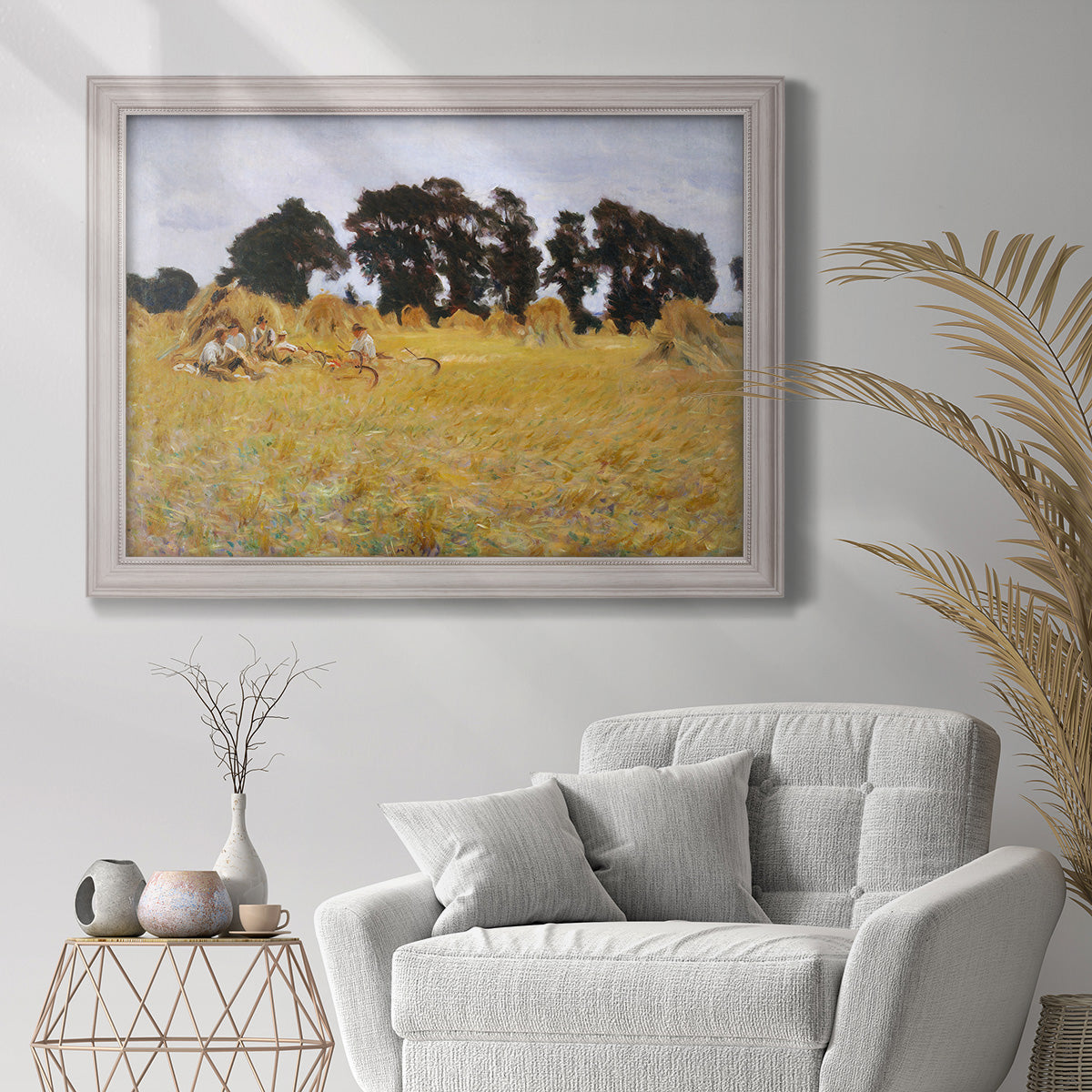 Impressionist rural harvest scene by John Singer Sargent in an ornate weathered white frame displayed in a bright interior setting.