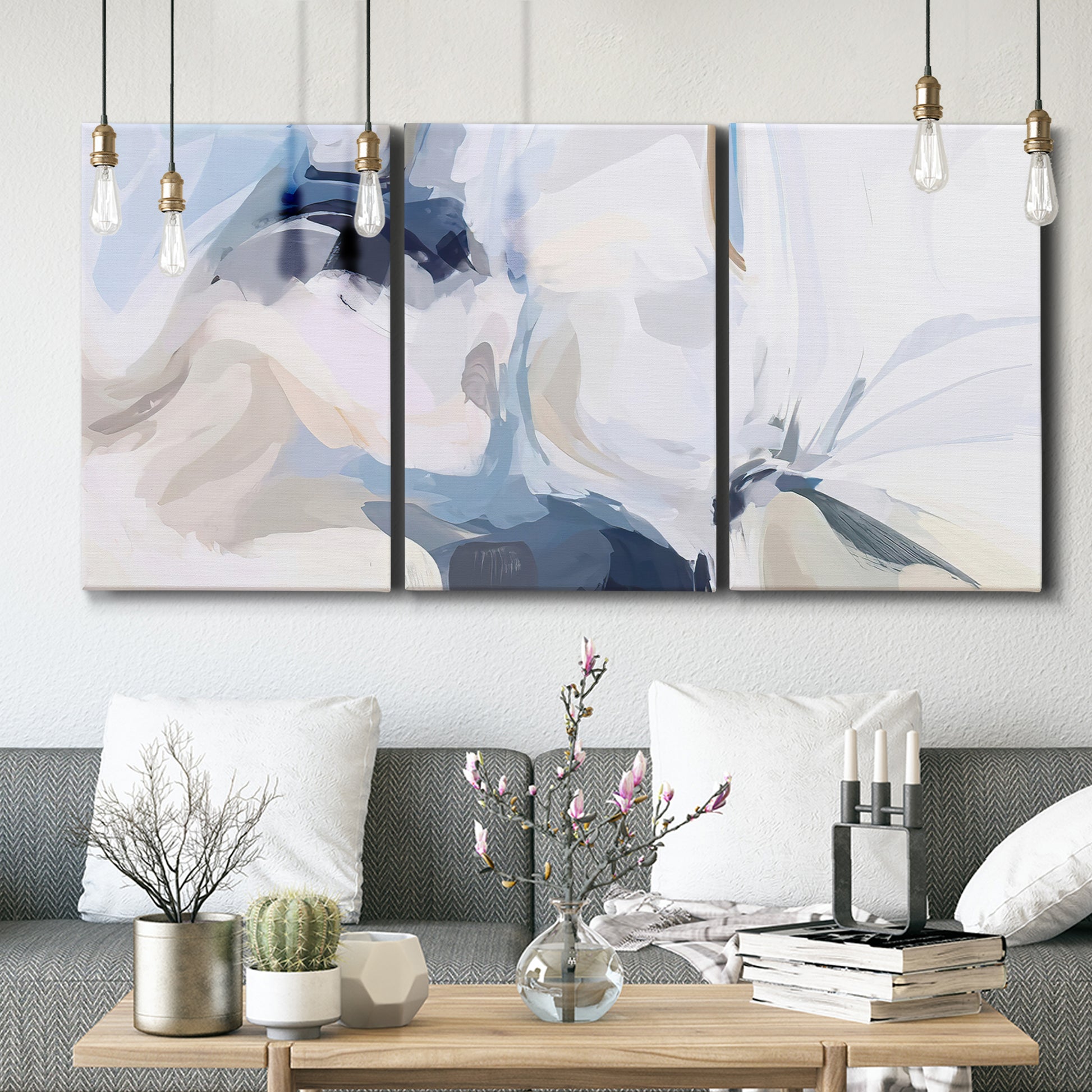 Three-panel canvas wall art featuring airy abstract movement composition, displayed in a modern living room above seating.
