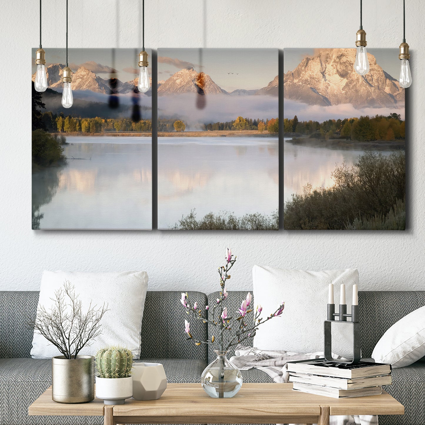 Three-panel canvas wall art featuring fog drifting over winding river, displayed in a modern living room above seating.