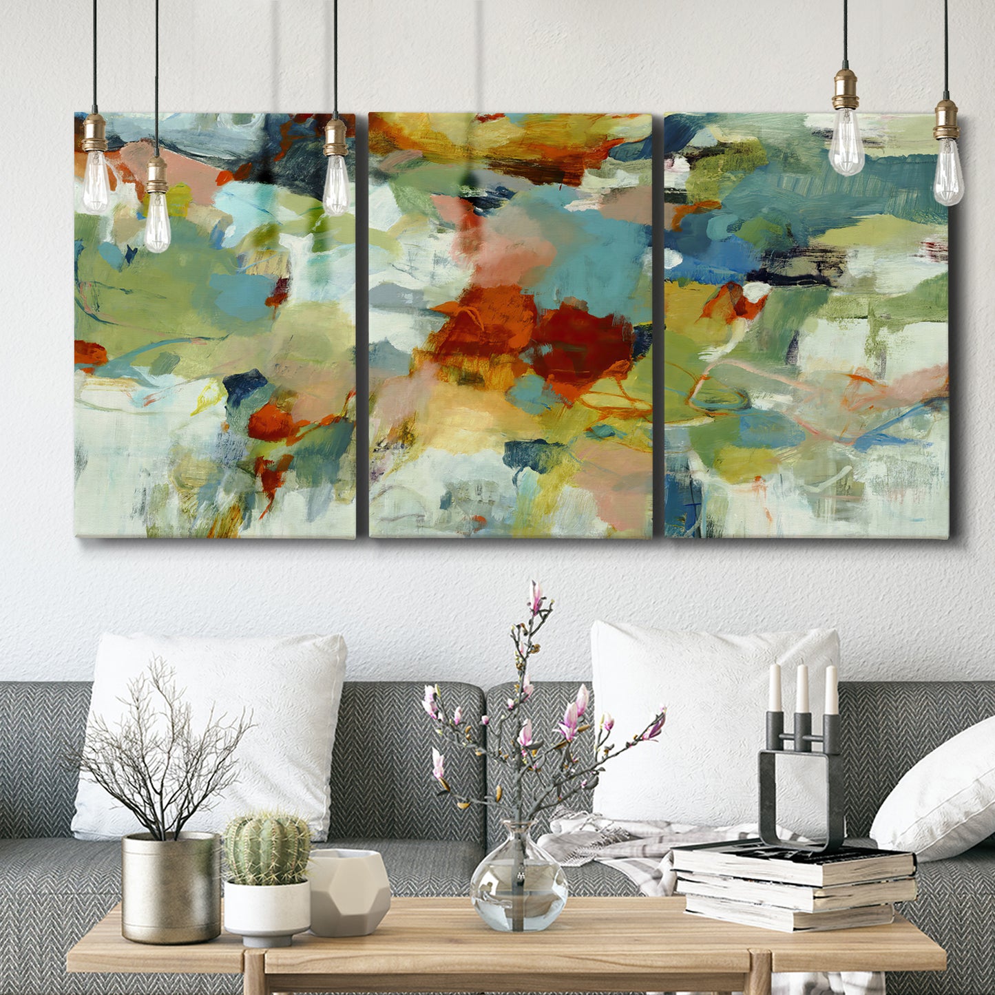 Three-panel canvas wall art featuring celebratory abstract color movement, displayed in a modern living room above seating.