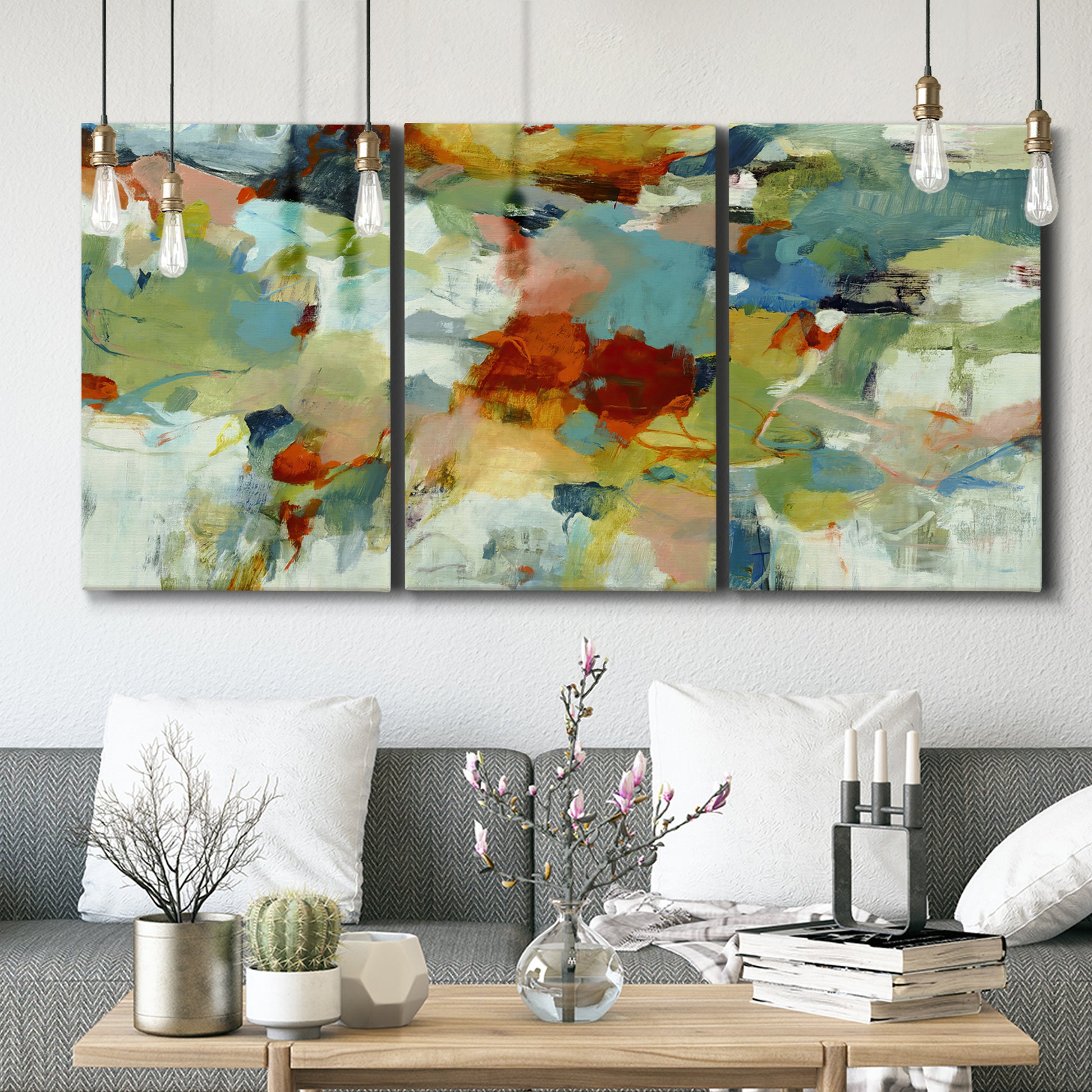 Three-panel canvas wall art featuring celebratory abstract color movement, displayed in a modern living room above seating.