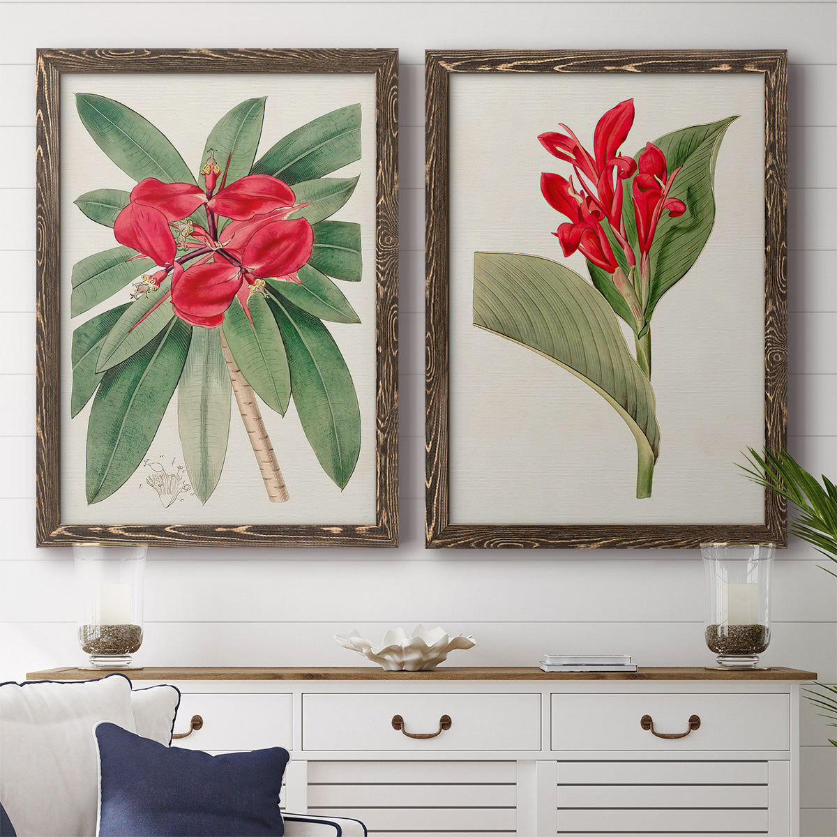 Set of two walnut barnwood framed canvas prints depicting a coordinated art pair of vivid tropical flowering plants rendered as antique botanical plate illustrations above a dining room sideboard.