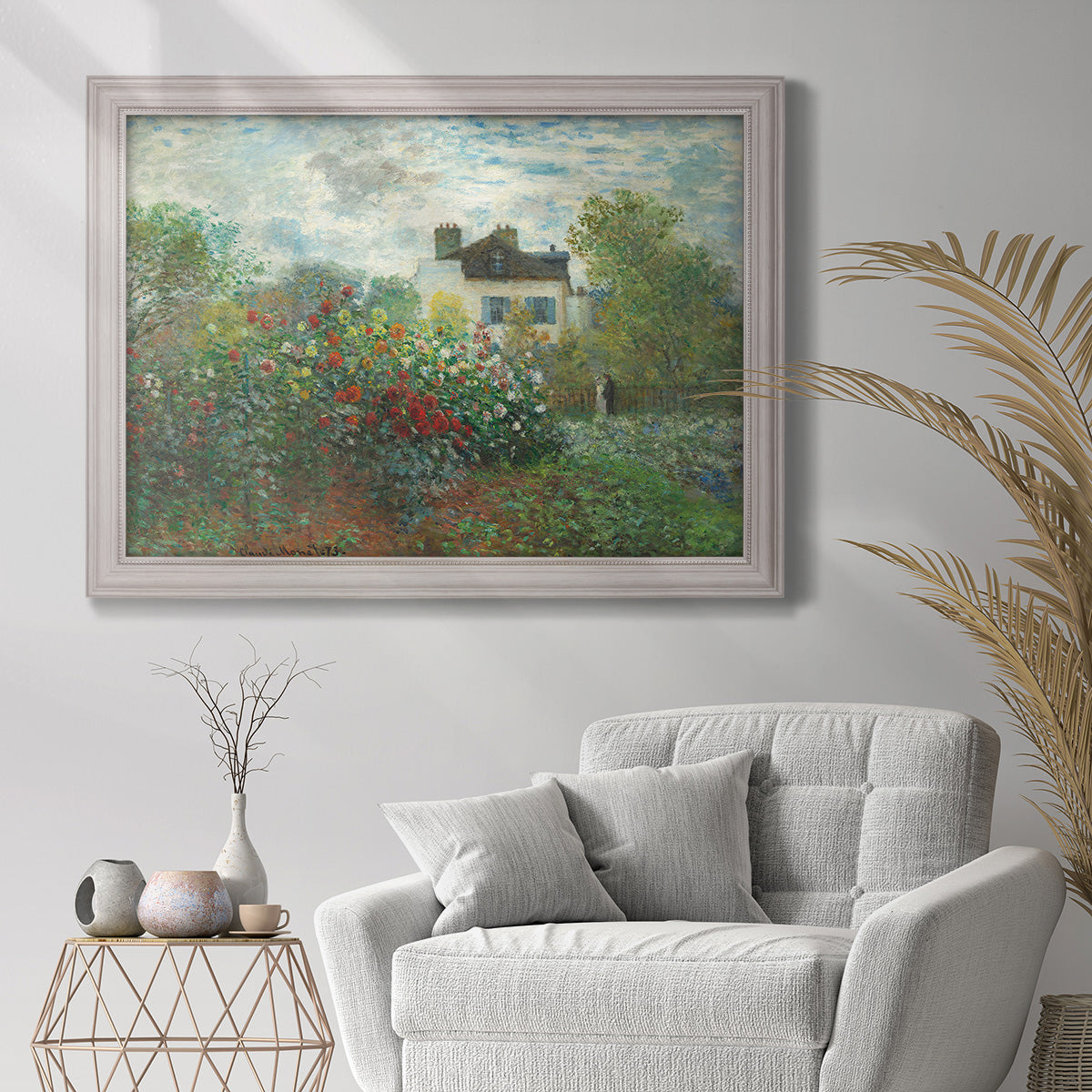 Impressionist garden landscape at Argenteuil by Claude Monet in an ornate weathered white frame displayed in a bright interior setting.