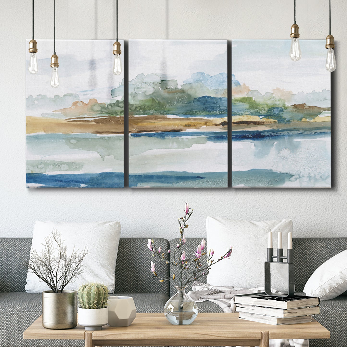 Three-panel canvas wall art featuring flowing blue abstract watercolor, displayed in a modern living room above seating.