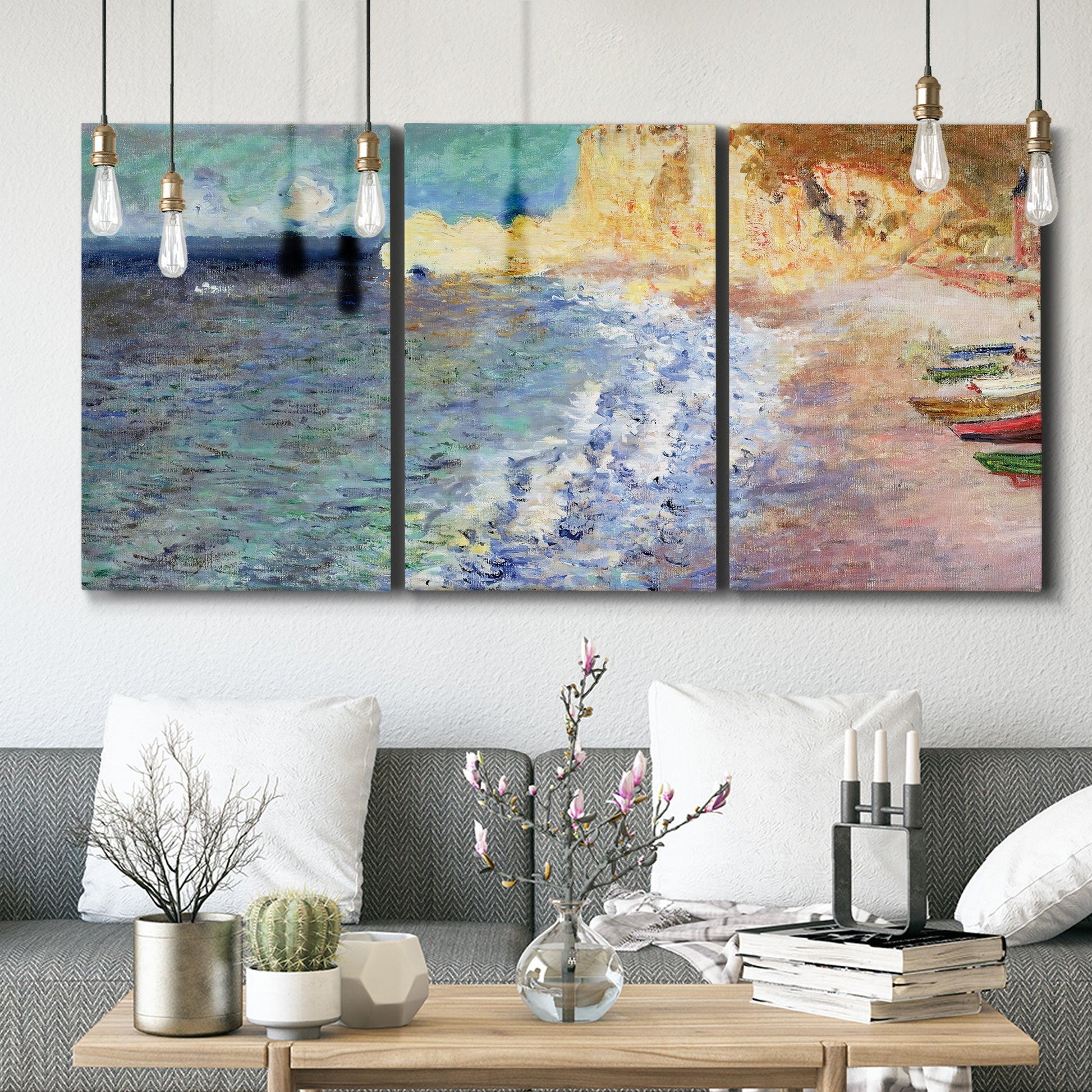 Three-panel canvas wall art featuring figures along rocky beach, displayed in a modern living room above seating.