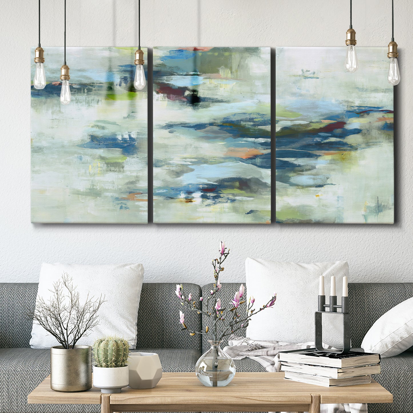 Three-panel canvas wall art featuring dreamlike abstract drifting motion, displayed in a modern living room above seating.