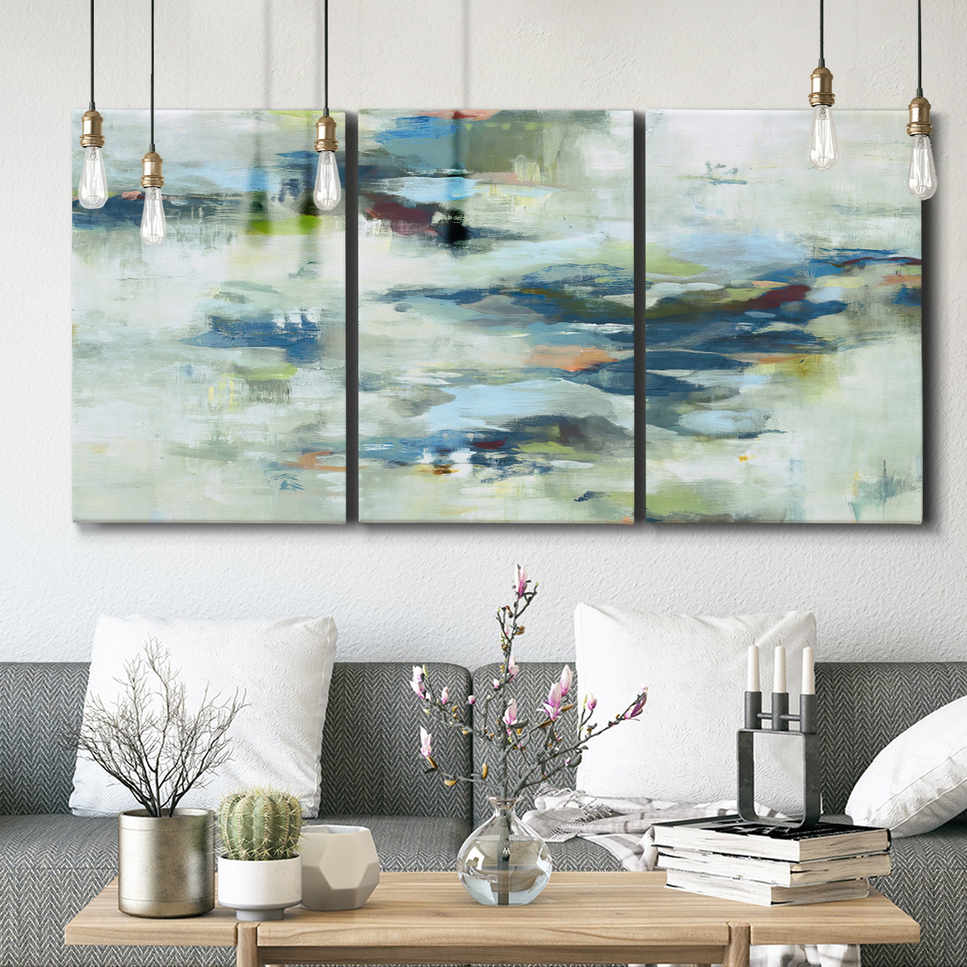 Three-panel canvas wall art featuring dreamlike abstract drifting motion, displayed in a modern living room above seating.