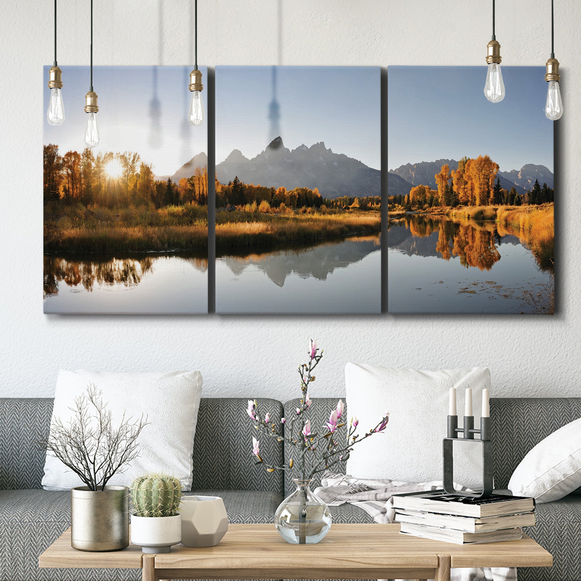 Three-panel canvas wall art featuring river canyon landscape photograph, displayed in a modern living room above seating.