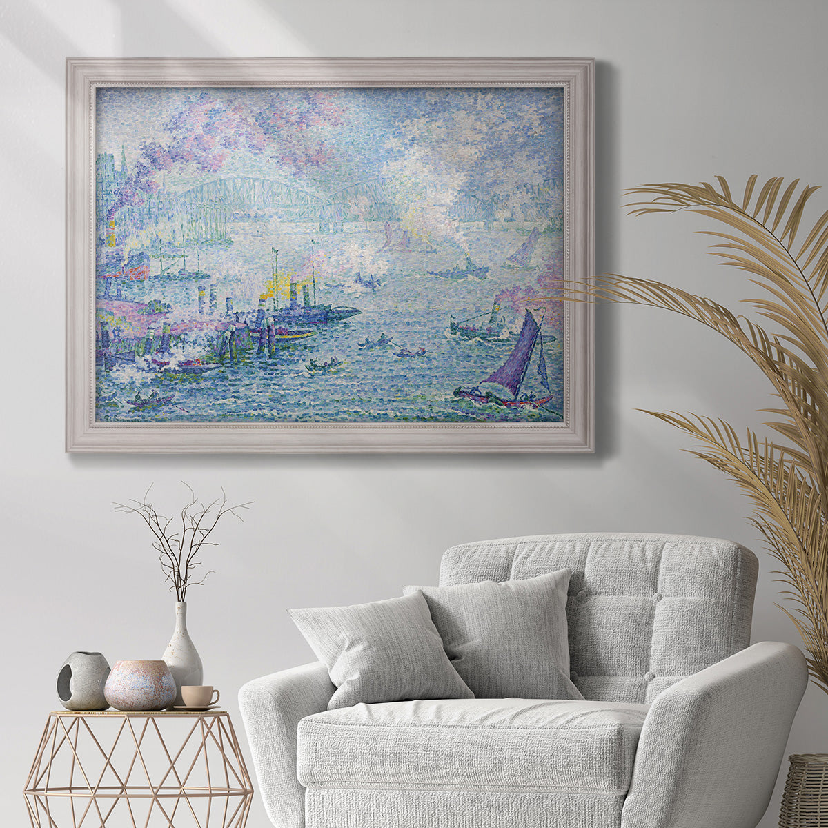 Impressionist industrial harbor scene by Paul Signac in an ornate weathered white frame displayed in a bright interior setting.