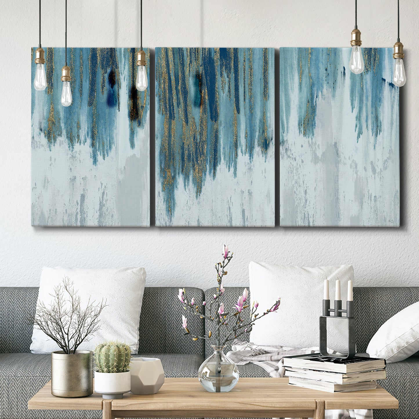 Three-panel canvas wall art featuring wide pastoral valley landscape, displayed in a modern living room above seating.