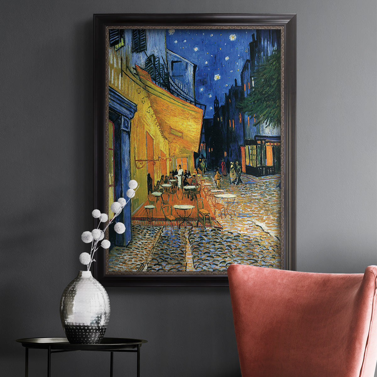 Impressionist night café street scene by Vincent van Gogh in an ornate black frame with gilded inner detail displayed in a dark-toned interior setting.