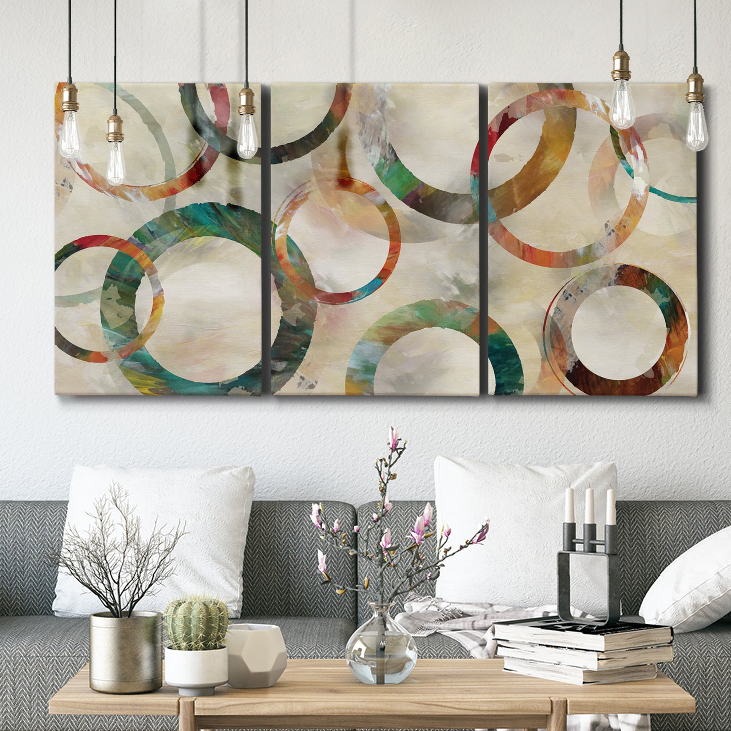 Three-panel canvas wall art featuring geometric circular abstract design, displayed in a modern living room above seating.