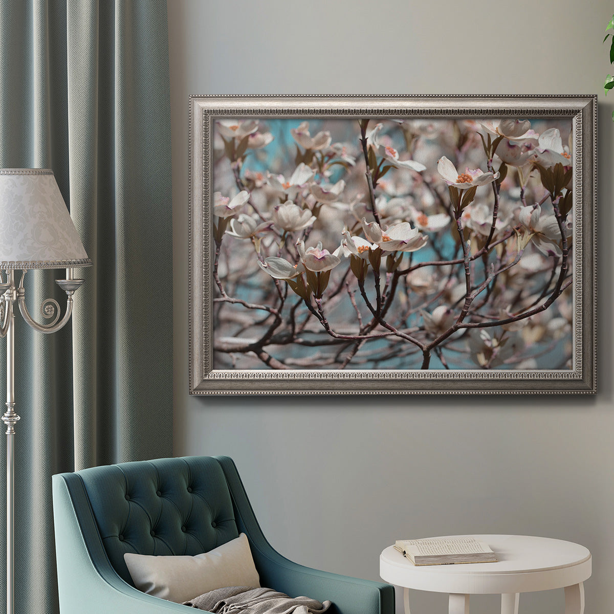 Contemporary dogwood blossom floral photography in an ornate vintage silver frame displayed in a neutral interior setting.
