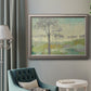 Traditional watercolor tree landscape artwork in an ornate vintage silver frame displayed in a neutral interior setting.