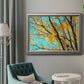 Bright autumn leaves against a blue sky in an ornate vintage silver frame displayed in a neutral interior setting.