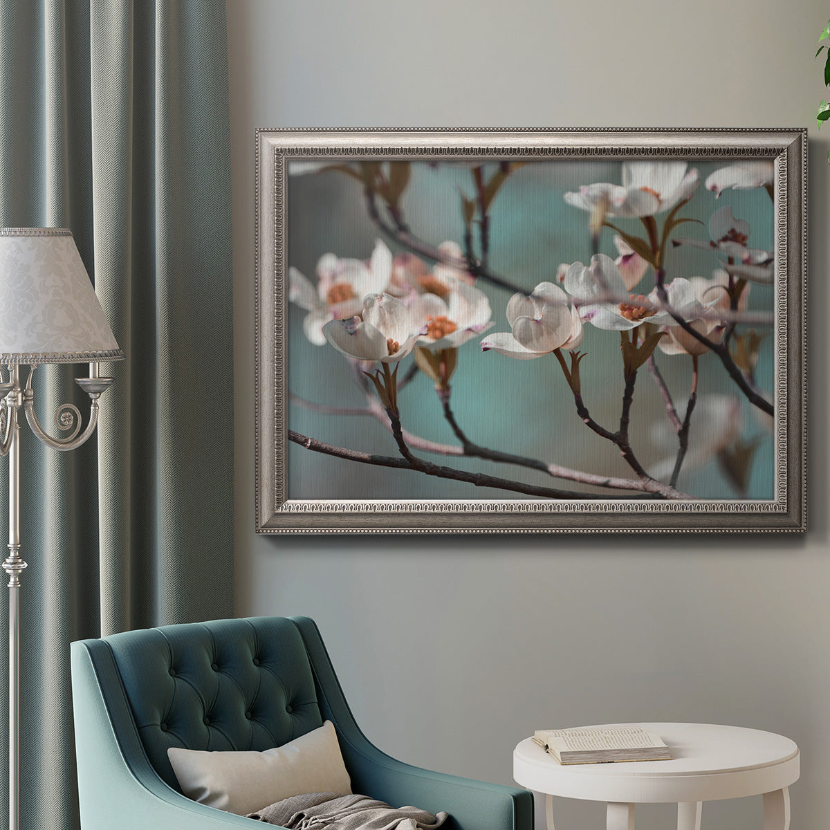 Close-up dogwood blossom photography in an ornate vintage silver frame displayed in a neutral interior setting.