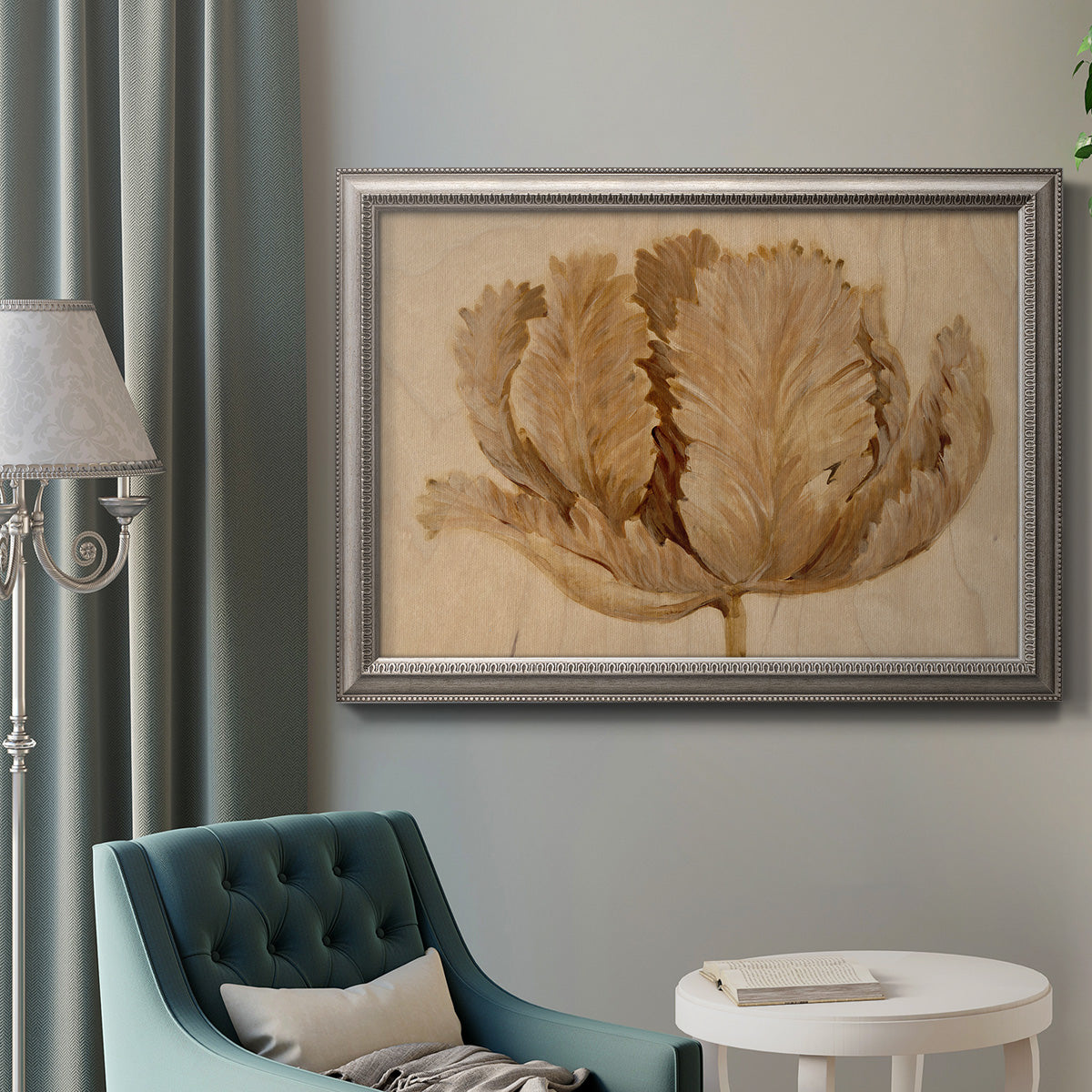Monochrome sepia tulip flower in an ornate vintage silver frame displayed in a neutral interior setting.