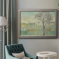 Classical watercolor landscape with trees in an ornate vintage silver frame displayed in a neutral interior setting.