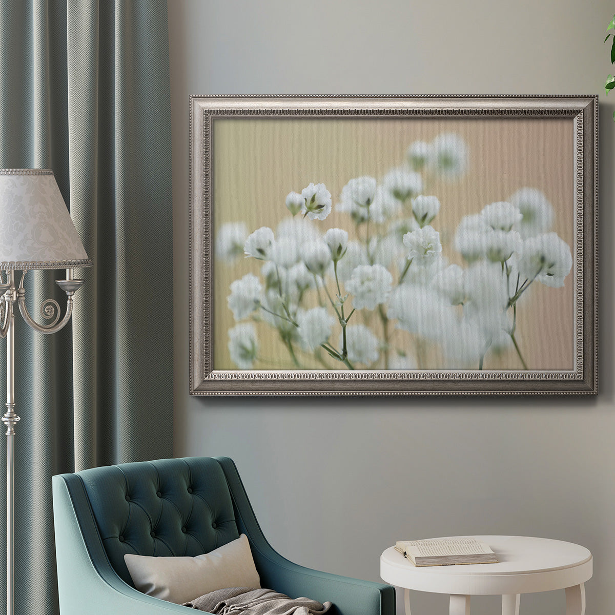 Delicate baby’s breath floral photograph in an ornate vintage silver frame displayed in a neutral interior setting.