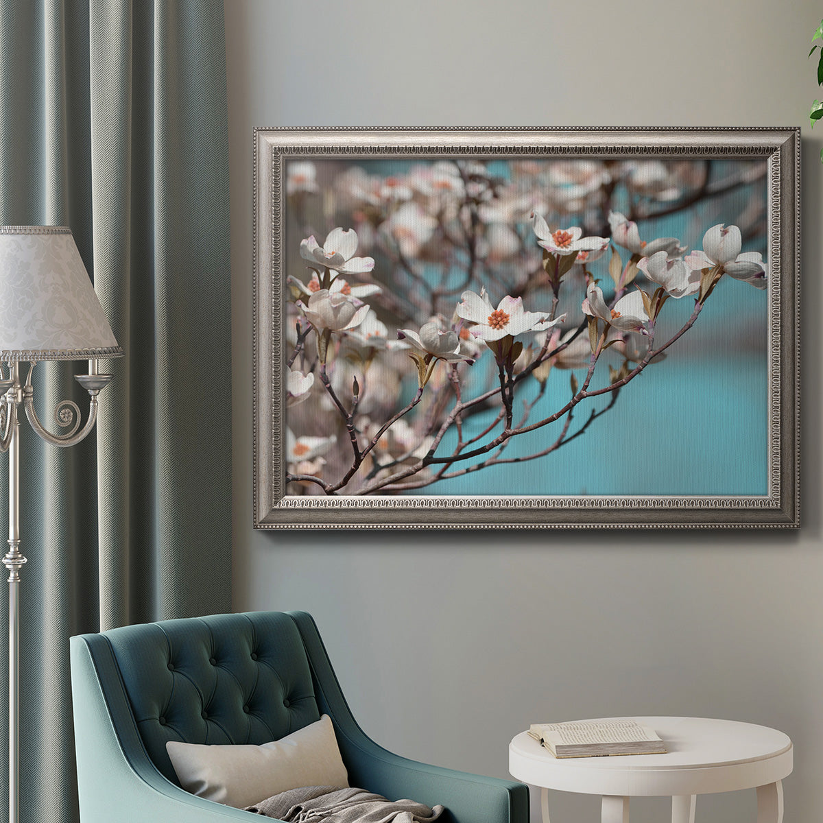 Color-rich dogwood floral photography in an ornate vintage silver frame displayed in a neutral interior setting.