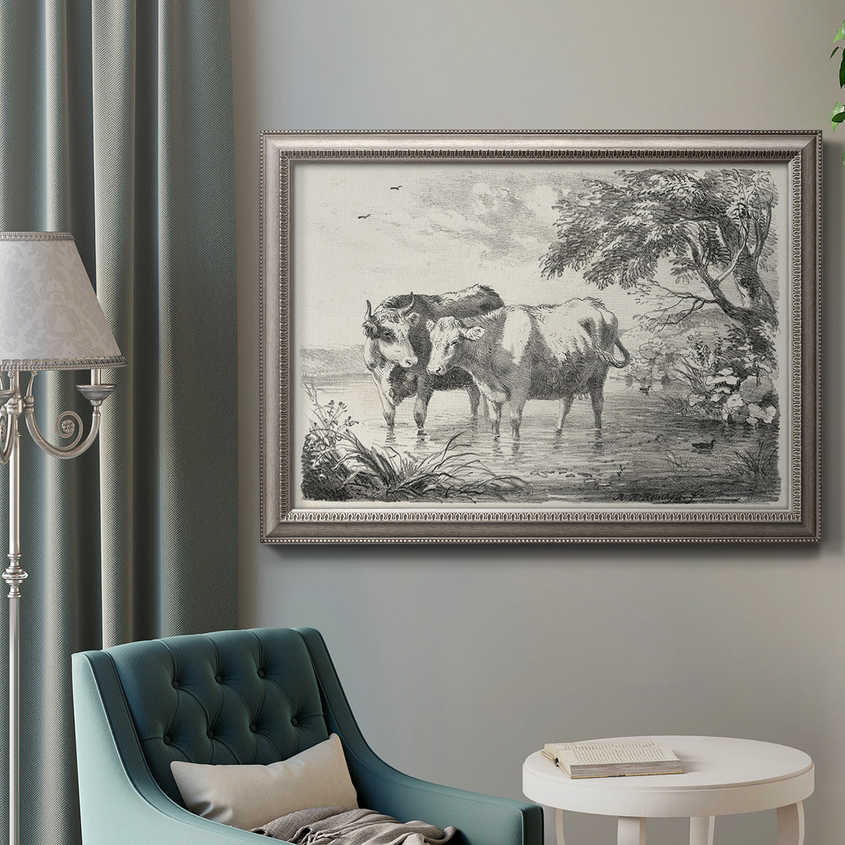 Classical countryside landscape artwork by Nicolas Berchem in an ornate vintage silver frame displayed in a neutral interior setting.