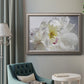 Soft white peony close-up in an ornate vintage silver frame displayed in a neutral interior setting.