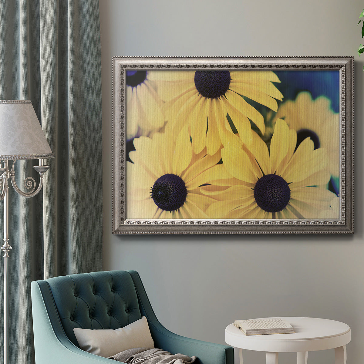 Modern sunflower-style Susan floral photograph in an ornate vintage silver frame displayed in a neutral interior setting.