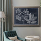 Antique botanical foliage artwork on navy background in an ornate vintage silver frame displayed in a neutral interior setting.