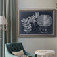 Vintage botanical foliage illustration on navy background in an ornate vintage silver frame displayed in a neutral interior setting.
