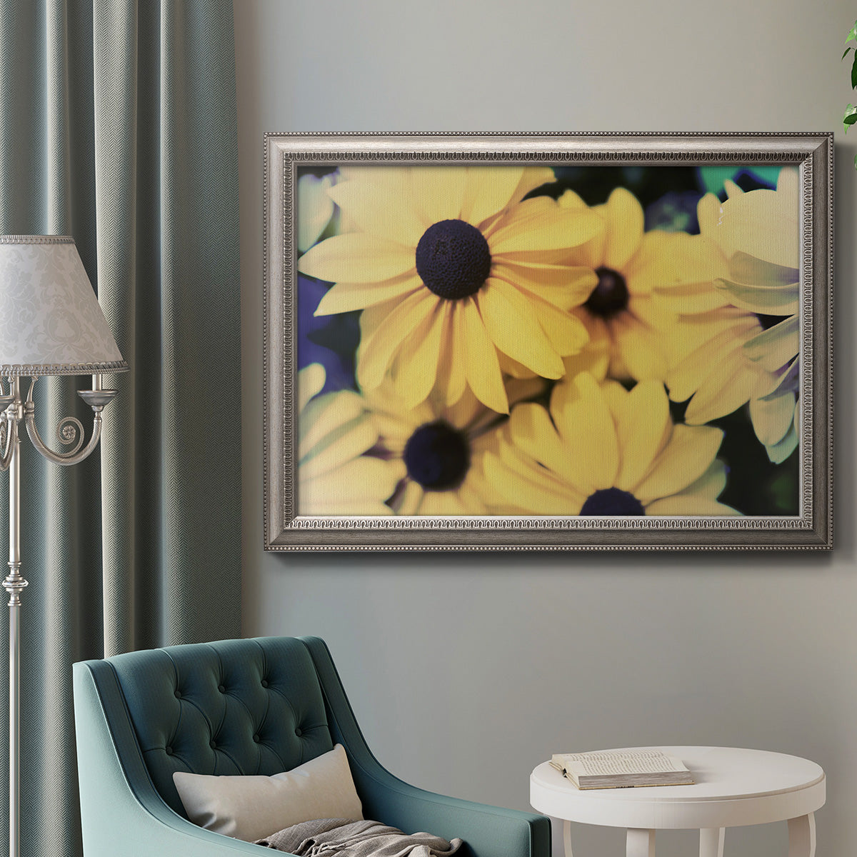Contemporary black-eyed Susan floral photography in an ornate vintage silver frame displayed in a neutral interior setting.