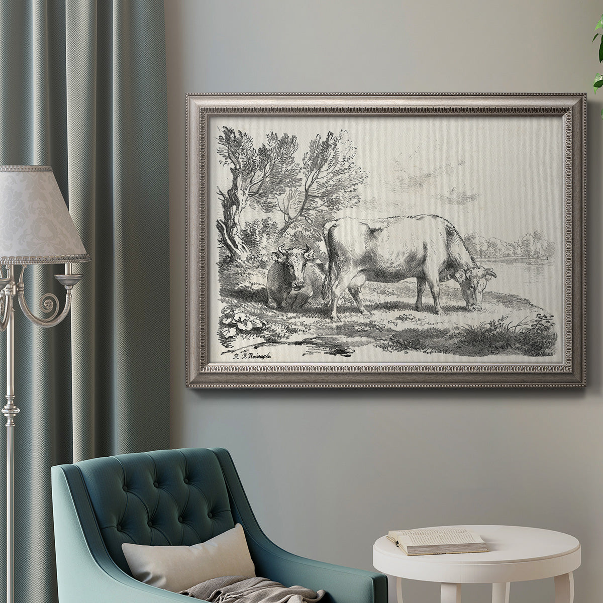 Traditional rural landscape scene by Nicolas Berchem in an ornate vintage silver frame displayed in a neutral interior setting.