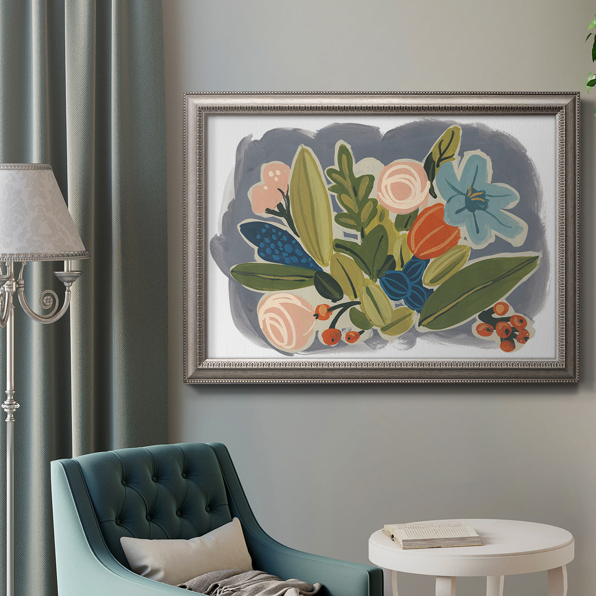Colorful eclectic botanical artwork in an ornate vintage silver frame displayed in a neutral interior setting.