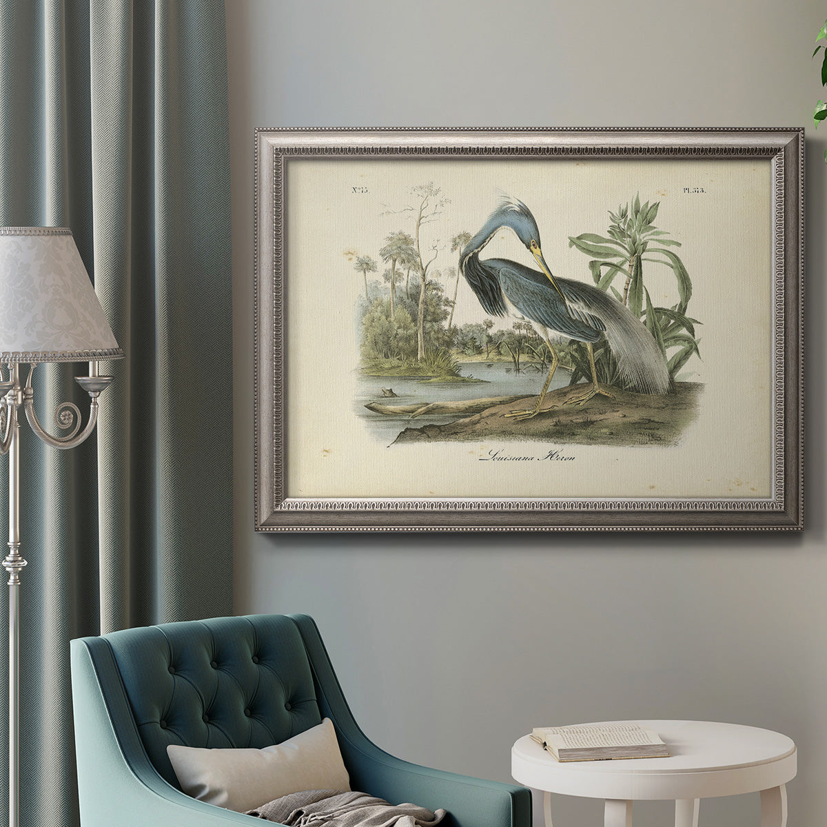 Antique Louisiana heron bird illustration by John James Audubon in an ornate vintage silver frame displayed in a neutral interior setting.