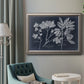 Vintage botanical leaf illustration on dark background in an ornate vintage silver frame displayed in a neutral interior setting.
