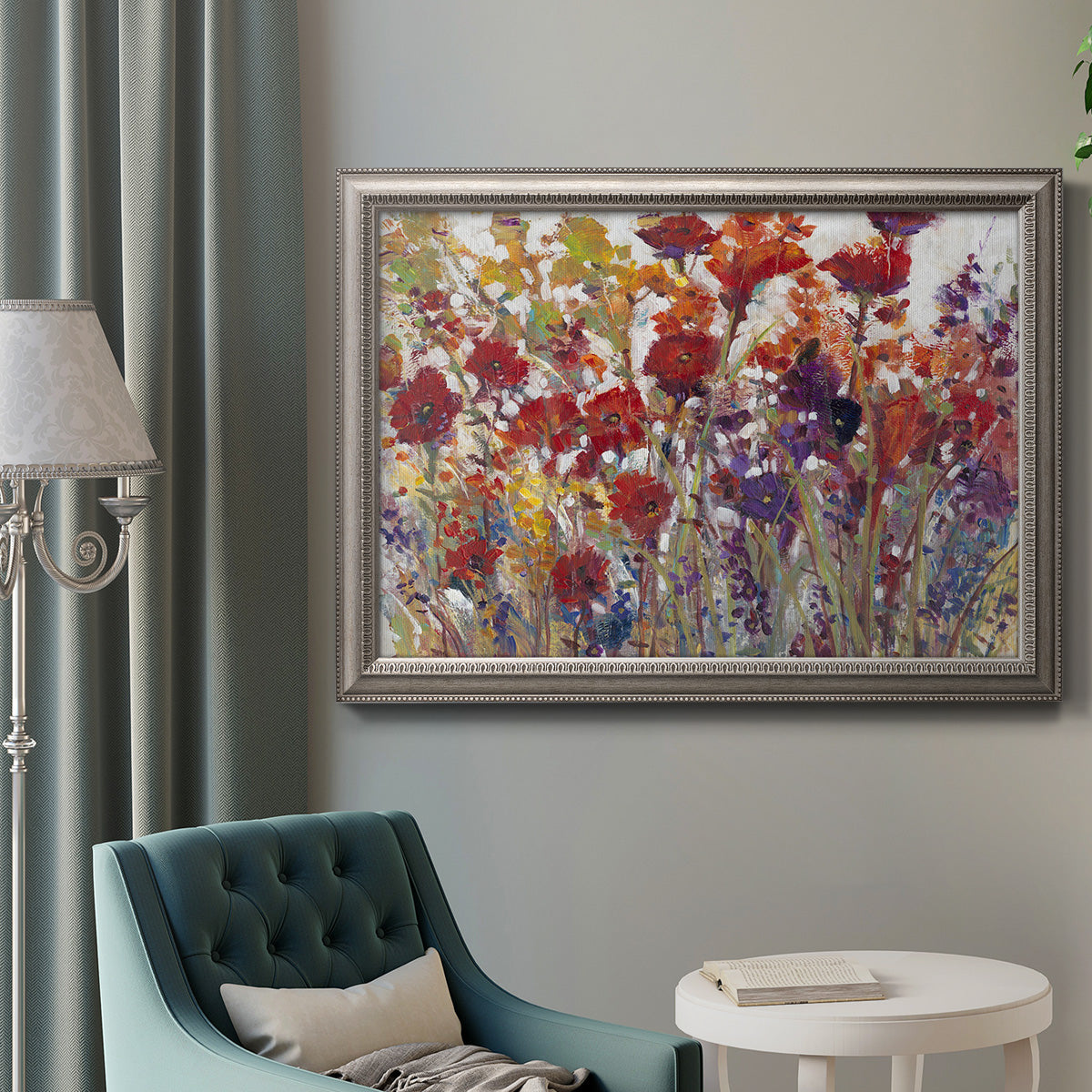 French country floral bouquet painting in an ornate vintage silver frame displayed in a neutral interior setting.