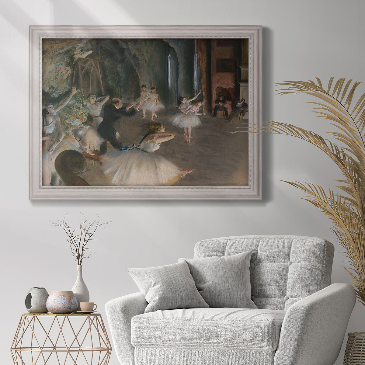 Impressionist backstage ballet scene by Edgar Degas in an ornate weathered white frame displayed in a bright interior setting.