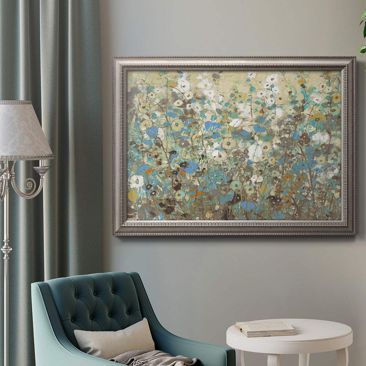 Impressionist flowering vine watercolor artwork in an ornate vintage silver frame displayed in a neutral interior setting.