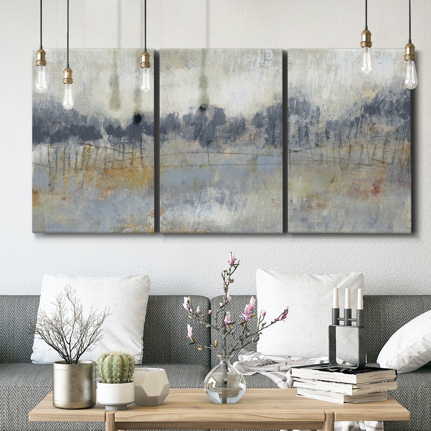 Three-panel canvas wall art featuring soft grey abstract horizon, displayed in a modern living room above seating.
