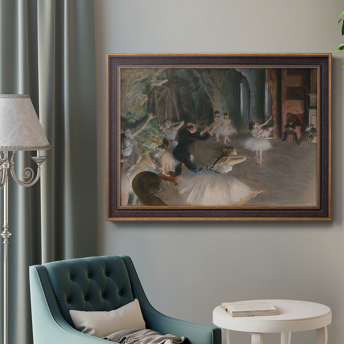 Impressionist backstage ballet scene by Edgar Degas in an ornate bronzed mahogany wood frame displayed in a bright interior setting.