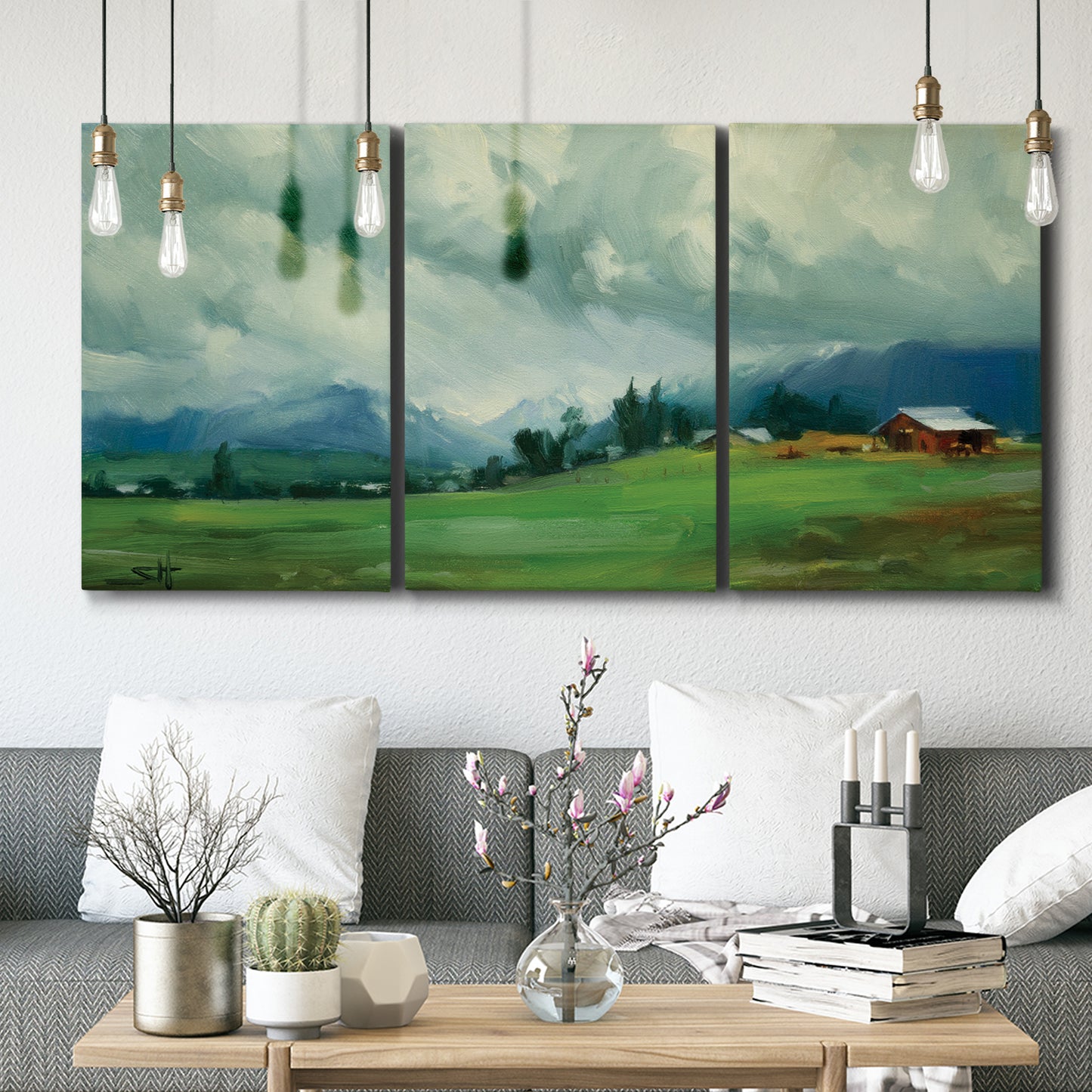 Three-panel canvas wall art featuring wide pastoral valley landscape, displayed in a modern living room above seating.