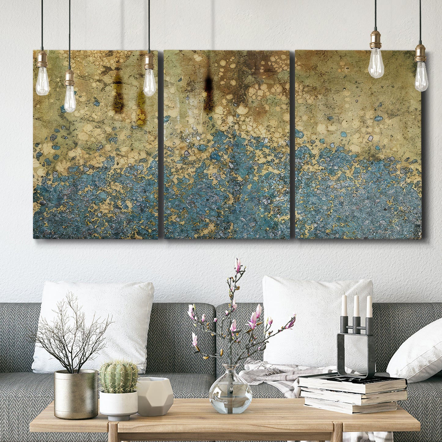 Three-panel canvas wall art featuring metallic abstract gold tones, displayed in a modern living room above seating.
