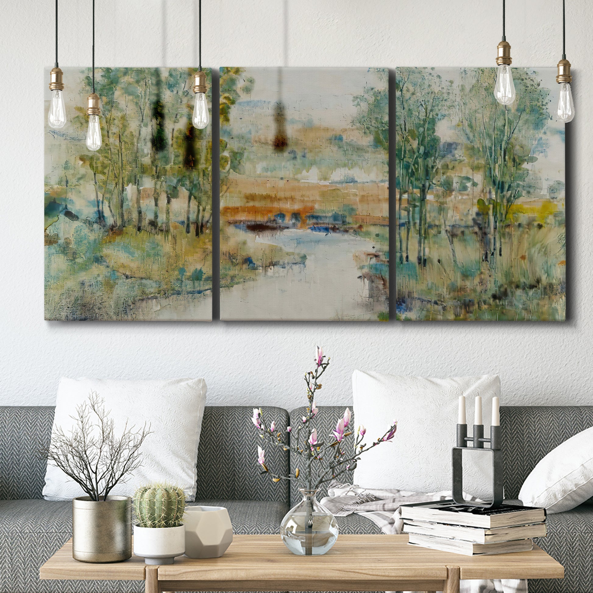Three-panel canvas wall art featuring trees lining quiet creek, displayed in a modern living room above seating.