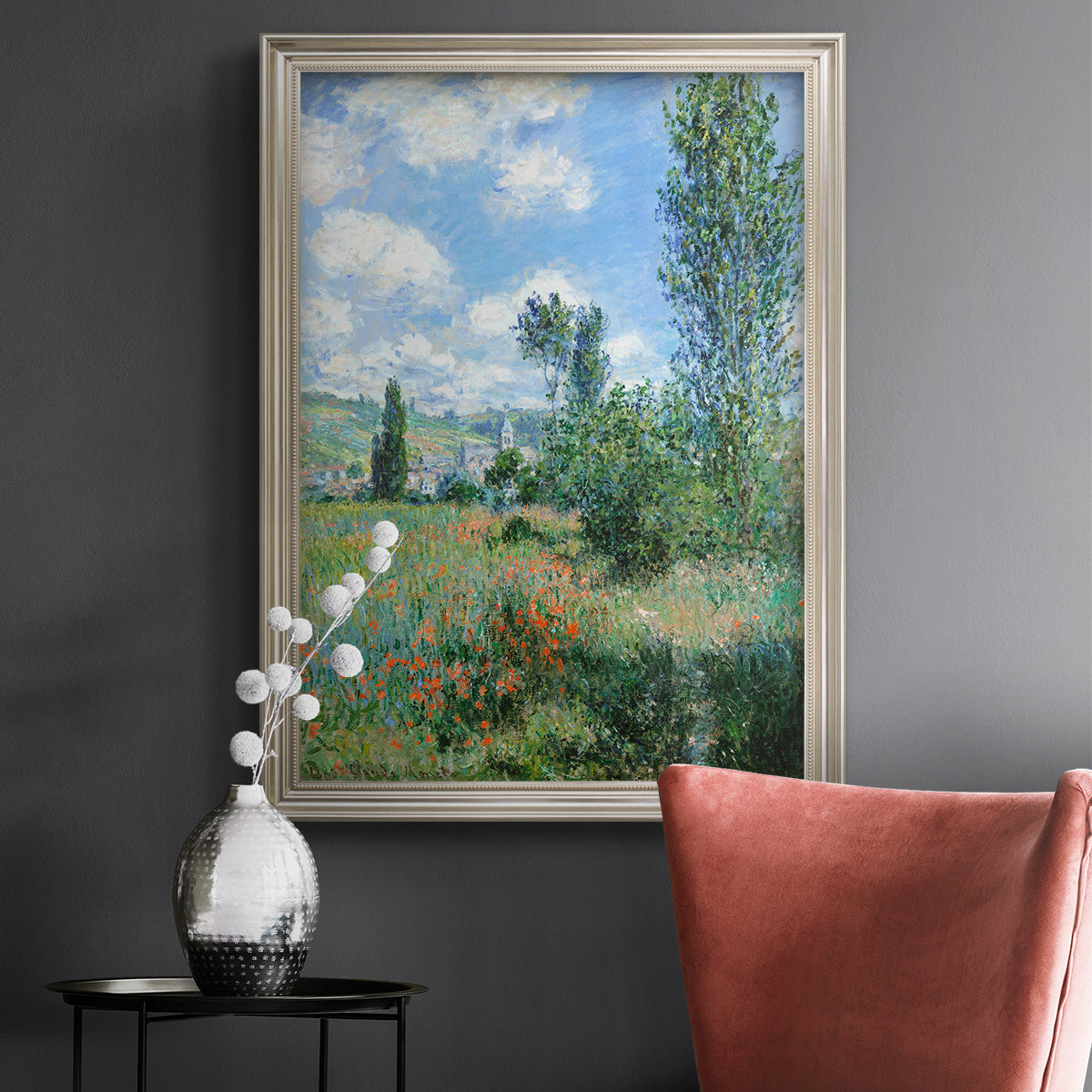 Impressionist pastoral landscape with poppy fields by Claude Monet in an ornate champagne frame displayed in a dark-toned interior setting.