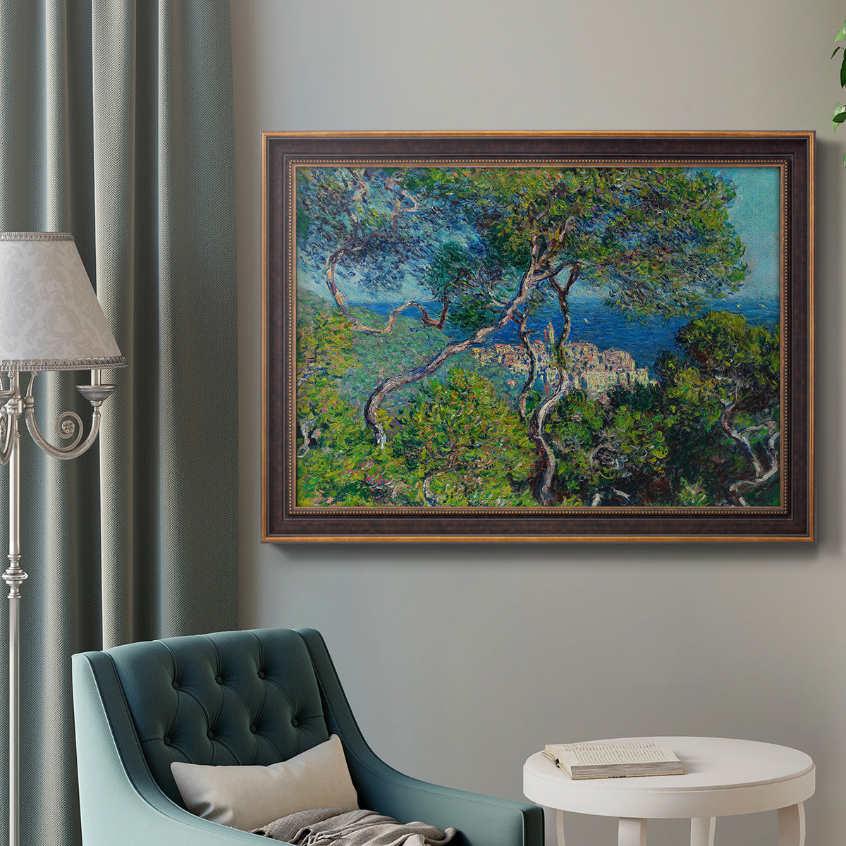 Impressionist Mediterranean coastal landscape by Claude Monet in an ornate bronzed mahogany wood frame displayed in a bright interior setting.