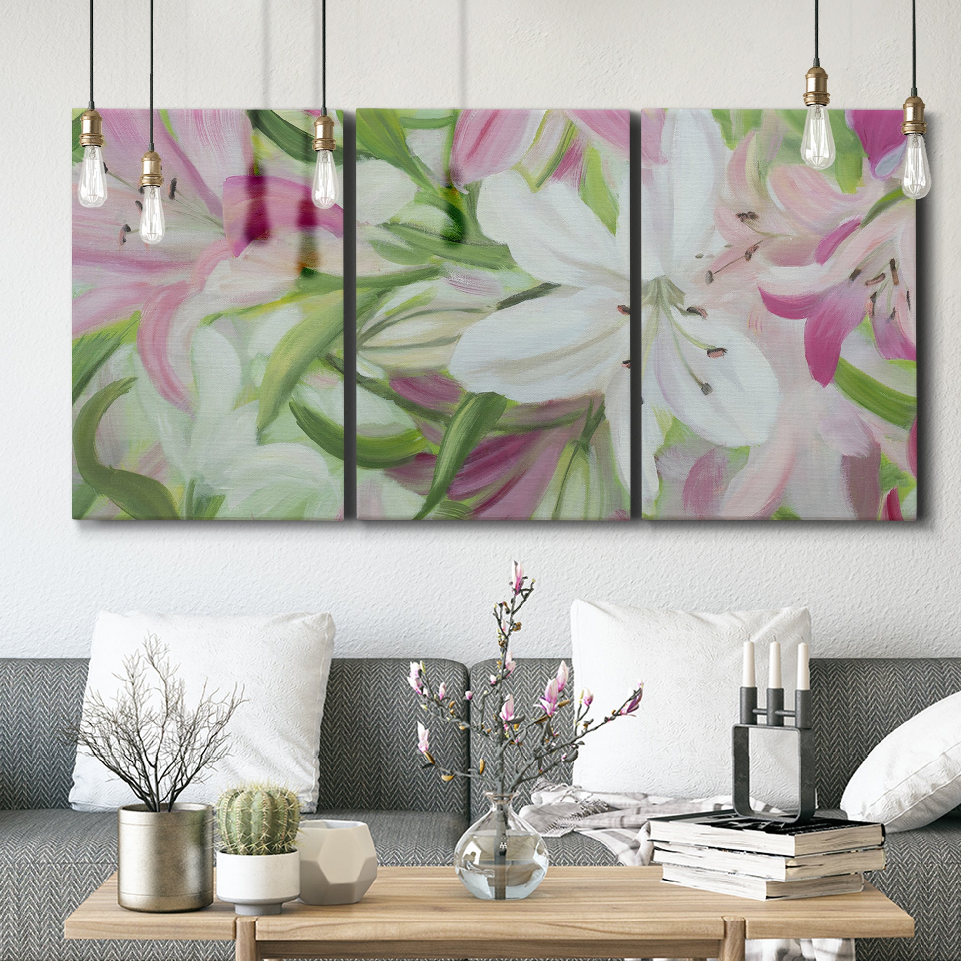Three-panel canvas wall art featuring pink and white lilies botanical study, displayed in a modern living room above seating.