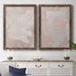 Set of two walnut barnwood framed canvas prints depicting a coordinated art pair of soft blush and white painterly fields rendered as minimalist color-field abstracts above a dining room sideboard.