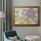 Contemporary peony flower illustration in an ornate traditional gold frame displayed in a neutral interior setting.