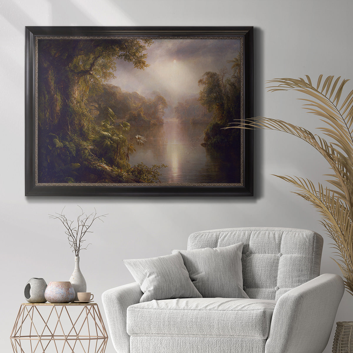 Luminous romantic landscape painting by Frederic Edwin Church in an ornate black frame with gilded inner detail displayed in a bright interior setting.